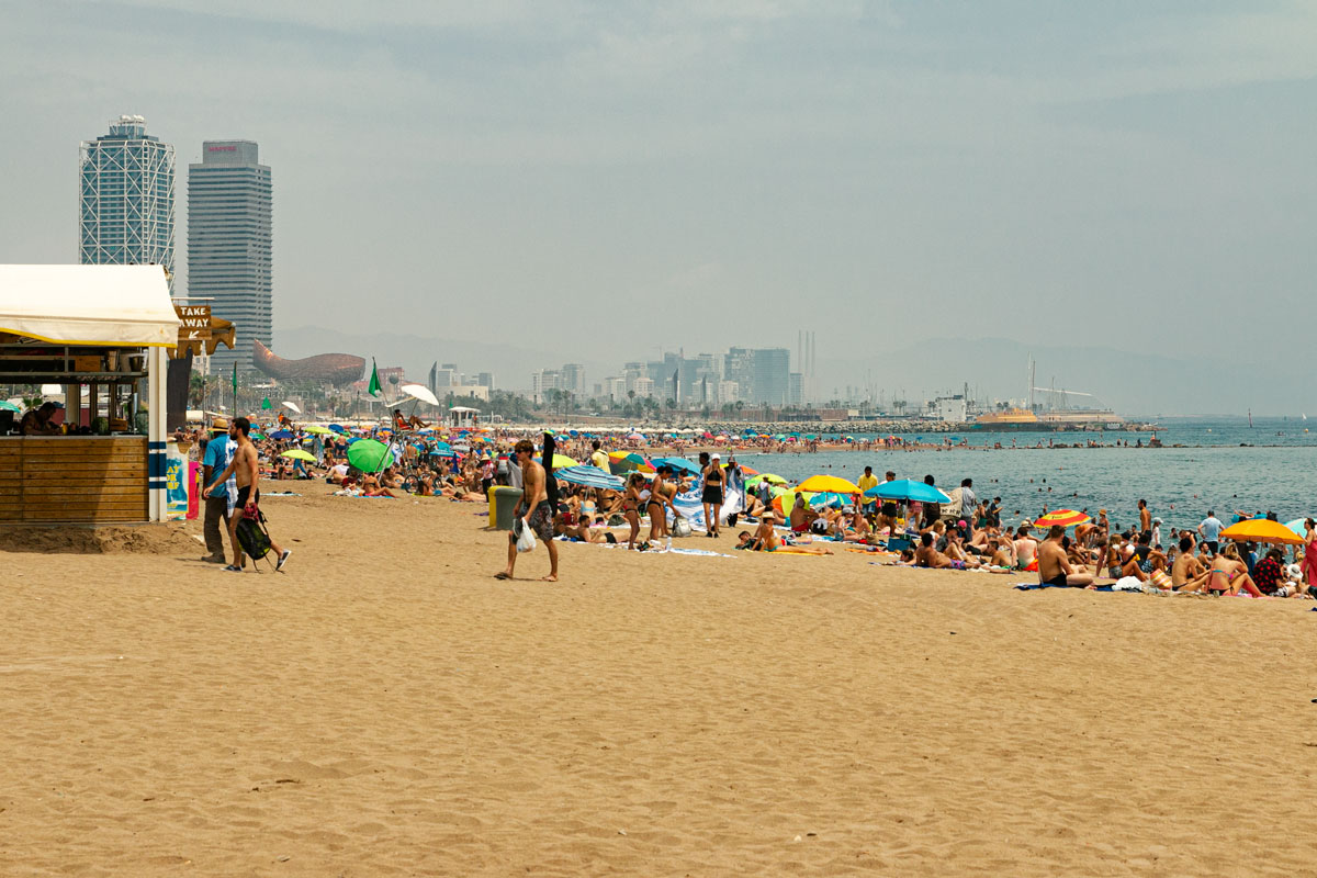 Mit Sonnenschirmen und Handtüchern bedeckter Stadtstrand.