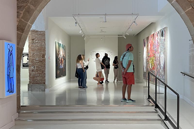 Vorwiegend junte Museumsbesucher stehen vor den einzelnen Kunstwerken.
