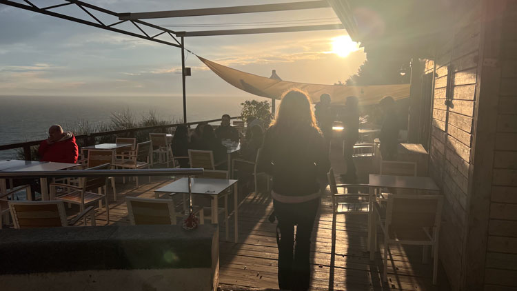 Die Terrasse der Bar am alten Leuchtturm von Tossa de Mar bei Sonnenuntergang.