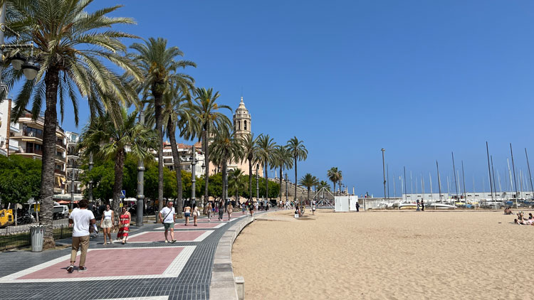 Die Strandpromenade zieht sich entlang der Strände, im Hintergrund thront die Kirche auf einer Anhöhe.