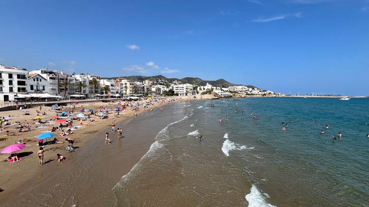 Der Strand San Sebastià hinter der Kirche von Sitges.