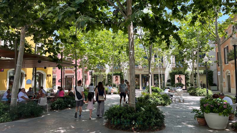 Zentraler Platz in Roca Village, mit Geschäften und Cafés.